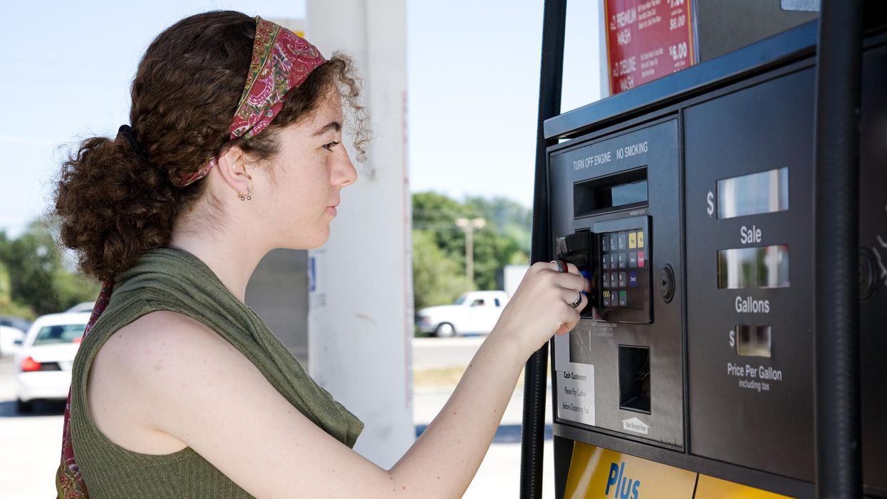 A woman paying for gas at a gas station.