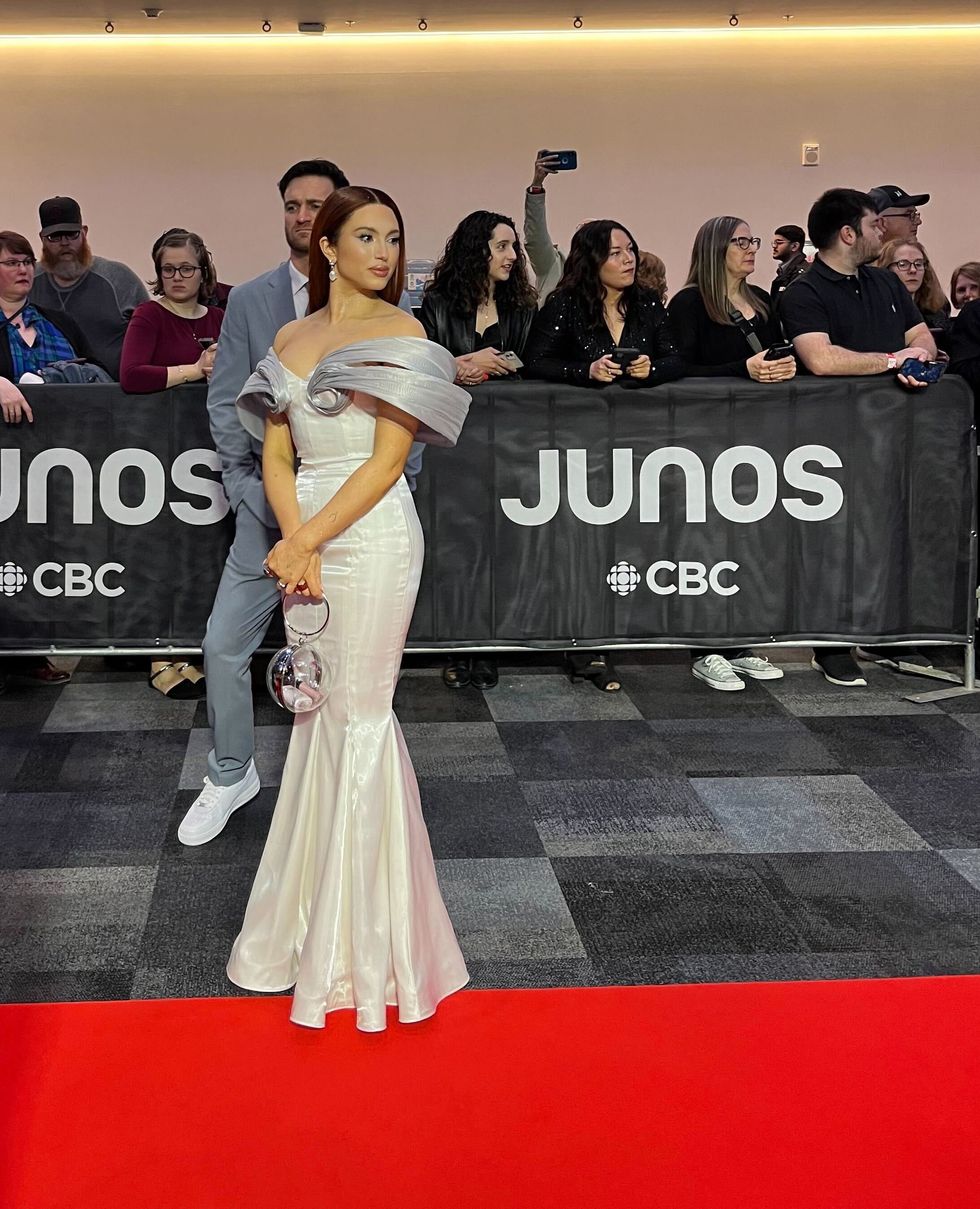 A woman posing in a white dress on the red carpet.