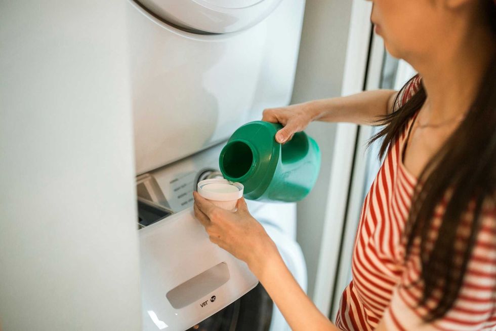 A woman pouring detergent.