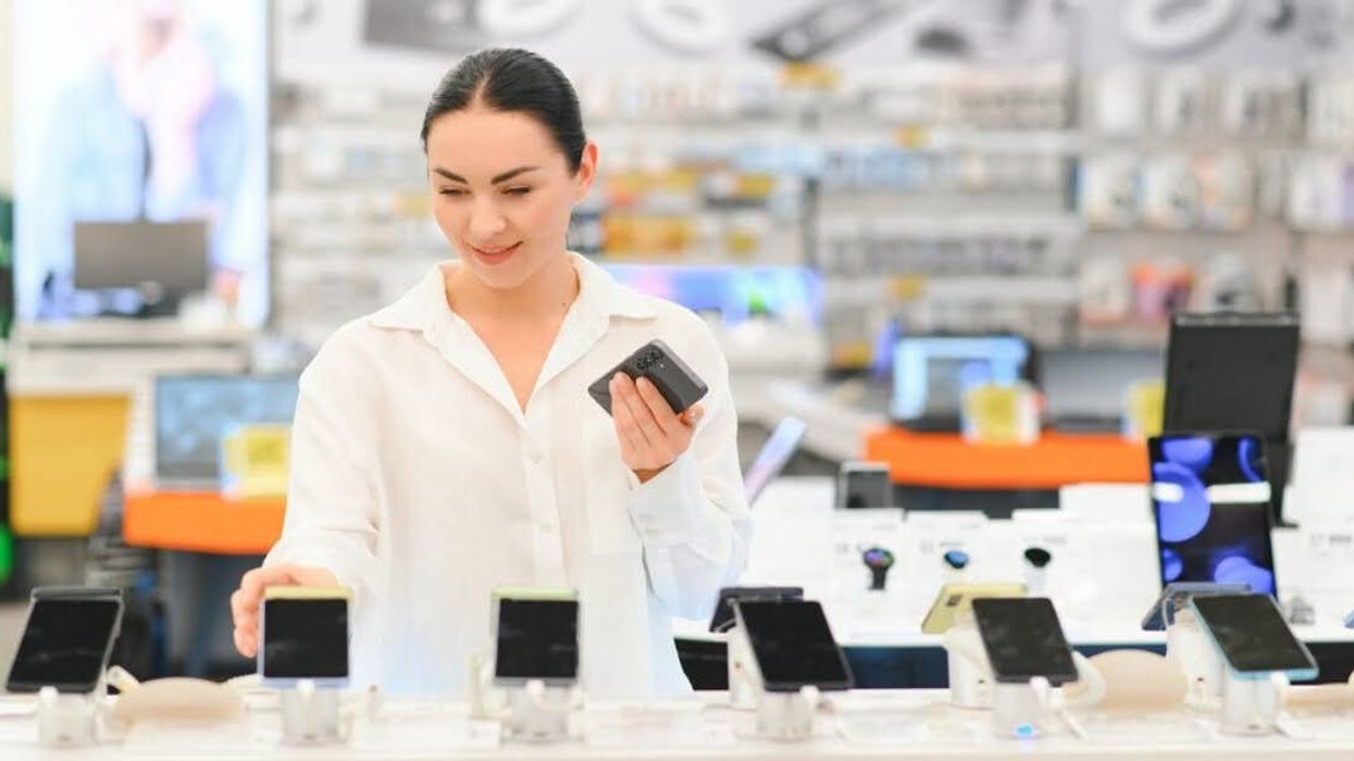 A woman shops for smartphones in an electronics store.