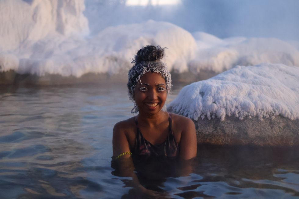 A woman showcases frosted hair and lashes.