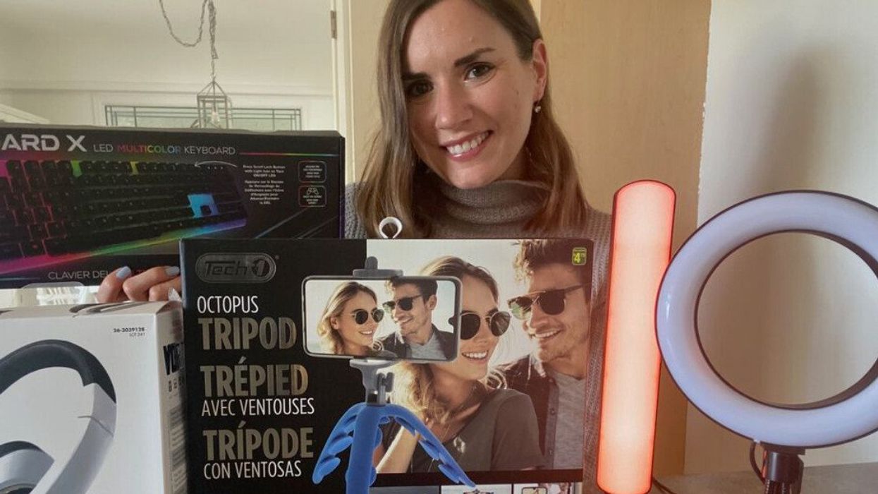 A woman standing behind a bunch of products.