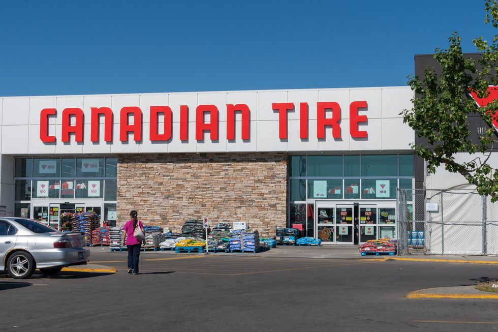 A woman walking into a Canadian Tire.