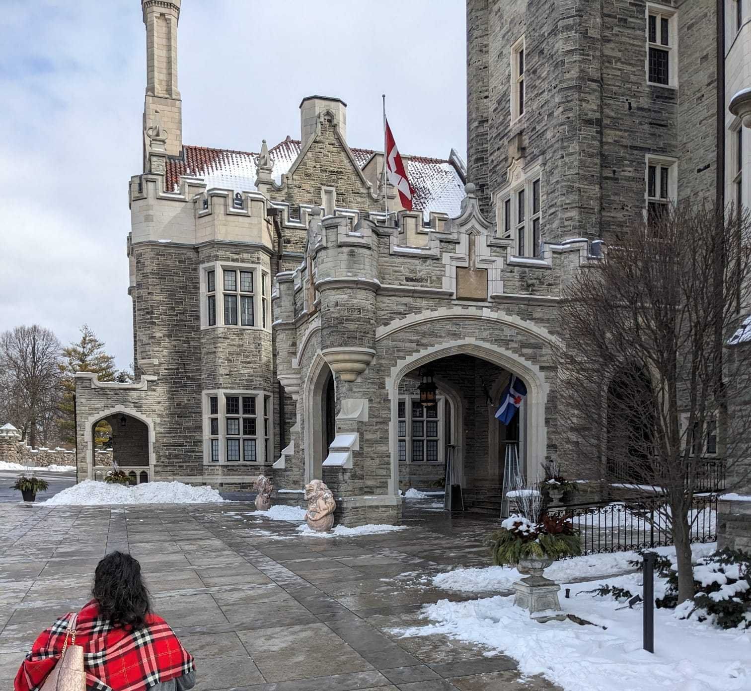 A woman walking towards Casa Loma.