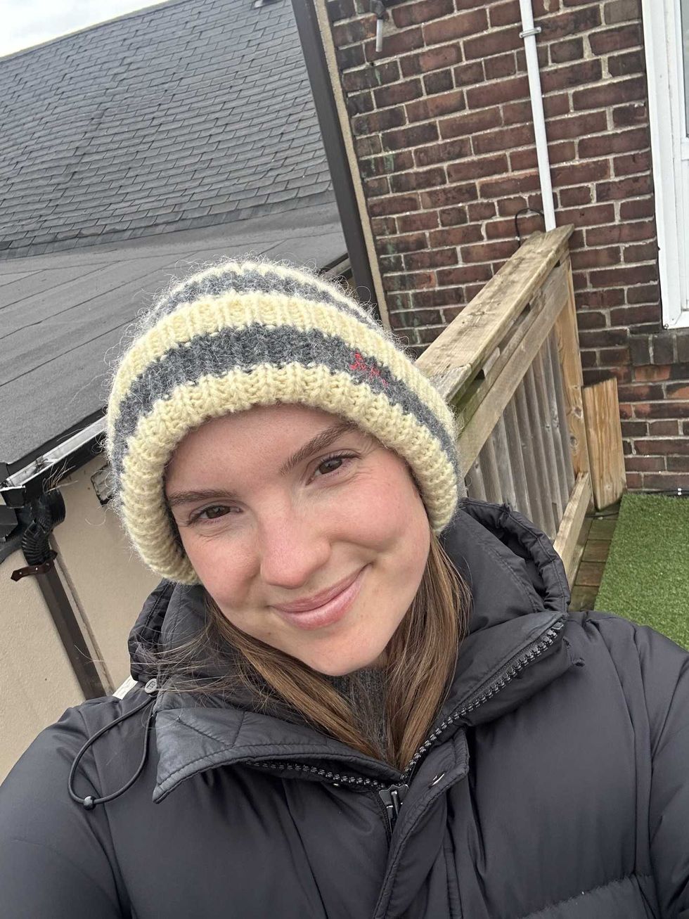 A woman wearing a winter hat and black puffer coat.