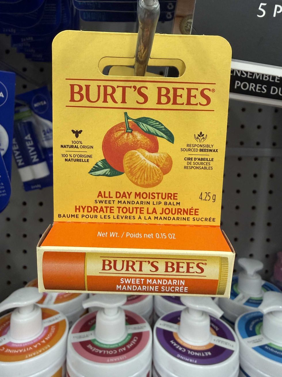 A yellow and orange box with a lip balm inside it and a mandarin on the front.