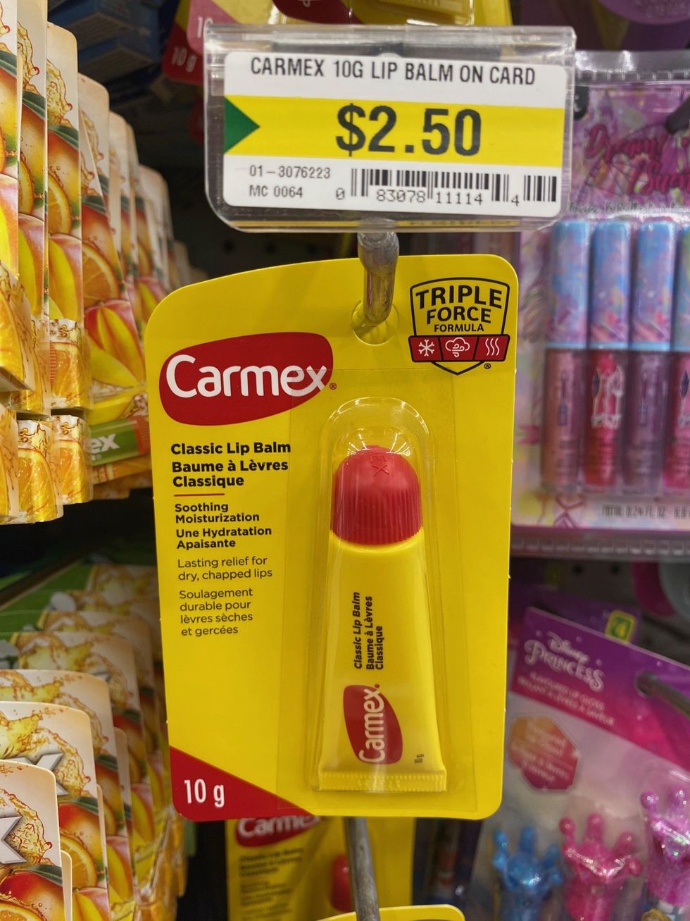 A yellow and red coloured tube of lip balm on sale at a store.