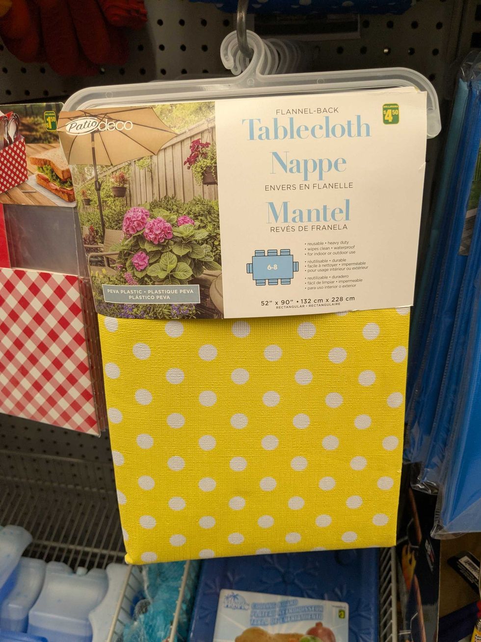 A yellow tablecloth with white polka dots hanging on the shelf