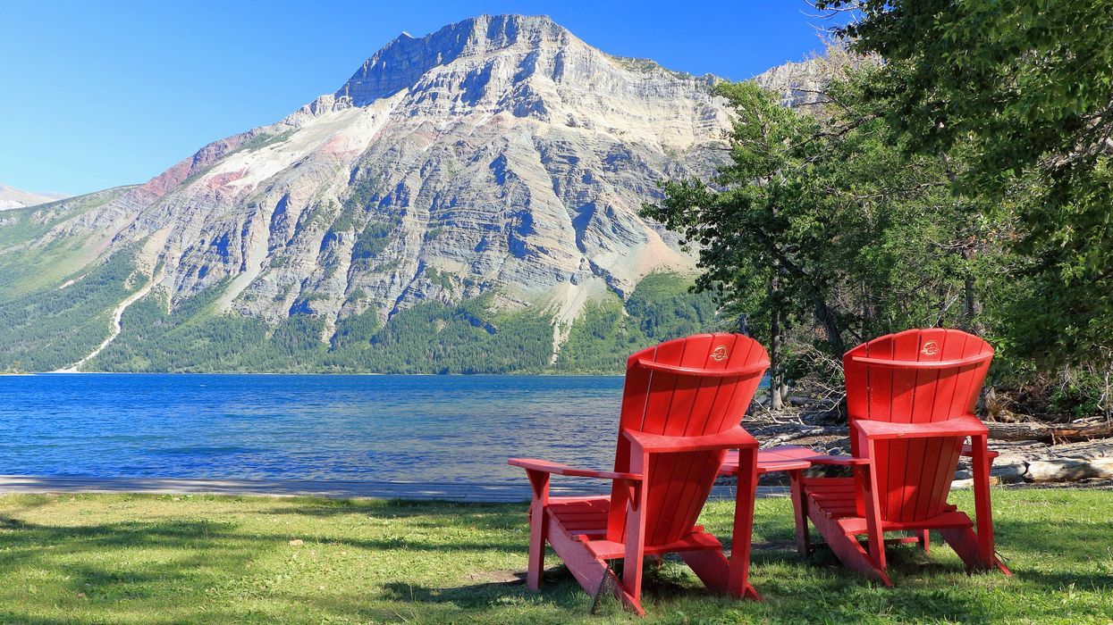 Adirondack chairs by a mountain.