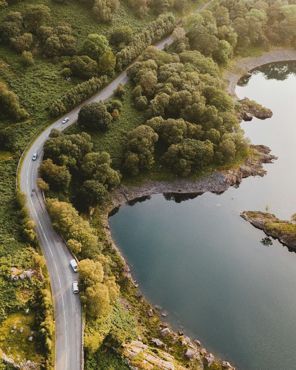 Aerial view of a cars on a road alongside water.
