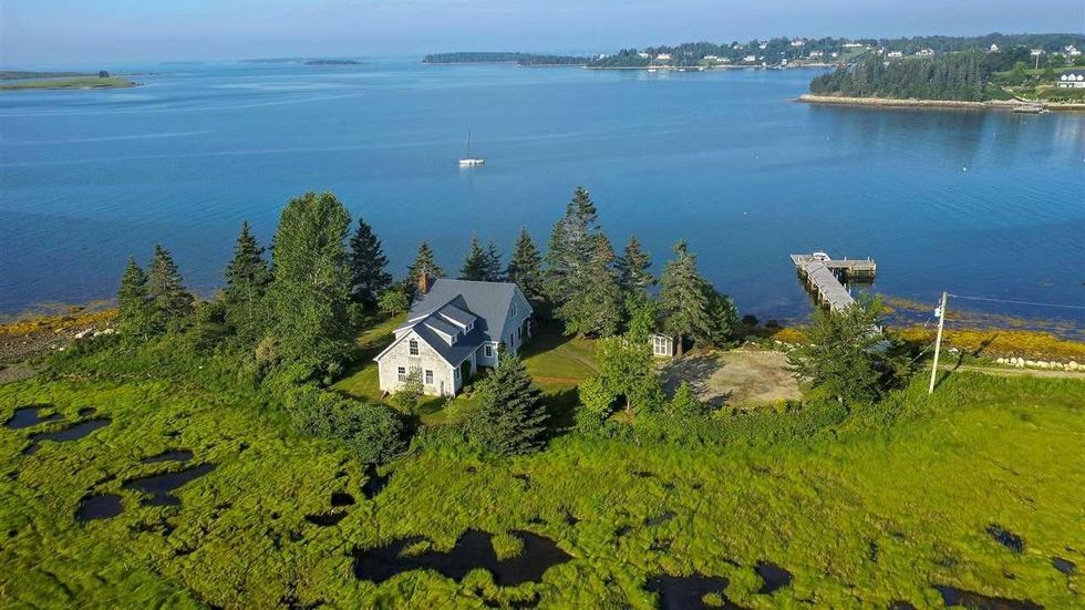 Aerial view of the house with the ocean in the background.