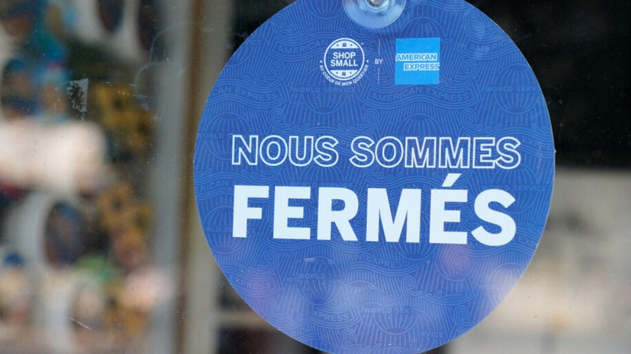 Affiche « nous sommes fermés » dans une porte d'un commerce.