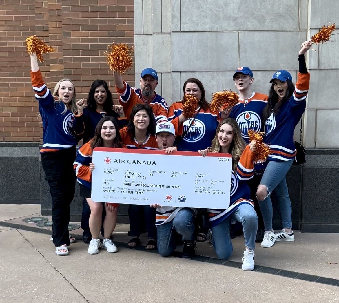 Air Canada Fan Flight winners pose with a giant ticket at the Oilers vs Dallas game.