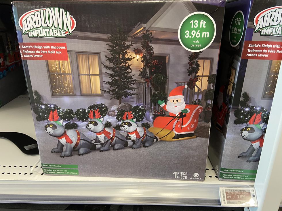 Airblown inflatable Christmas decoration of raccoons pulling Santa's sleigh.