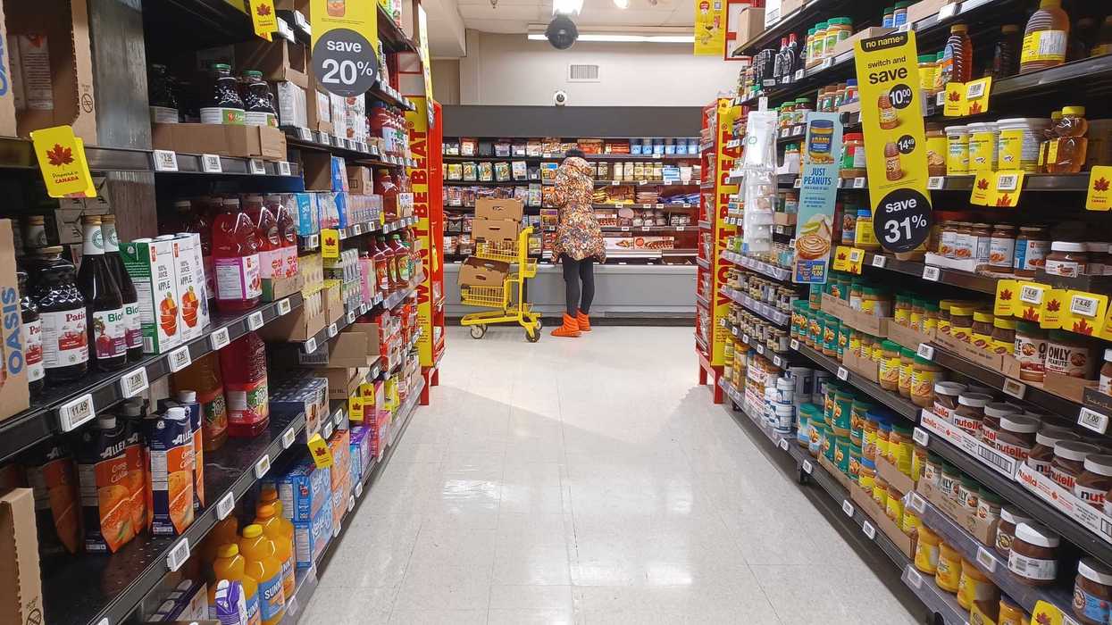 aisle with no name products and shopper at no frills grocery store in canada