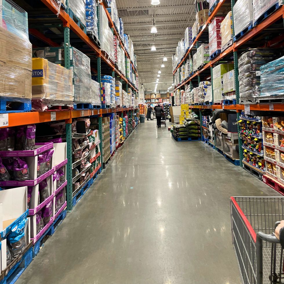 All\u00e9e d\u00e9di\u00e9e aux articles pour animaux \u00e0 la succursale Costco de Saint-J\u00e9r\u00f4me, avec des \u00e9tag\u00e8res remplies d'articles.