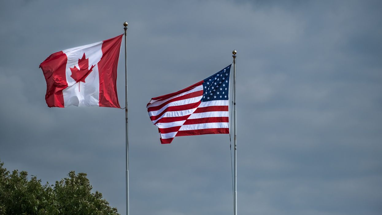 American and Canadian flags flying side by side at the border between USA-Canada.