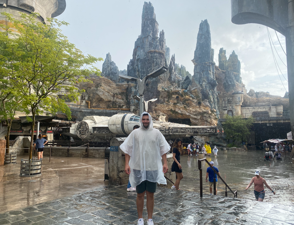 Amos looking soaked wearing a rain poncho in Disney World.