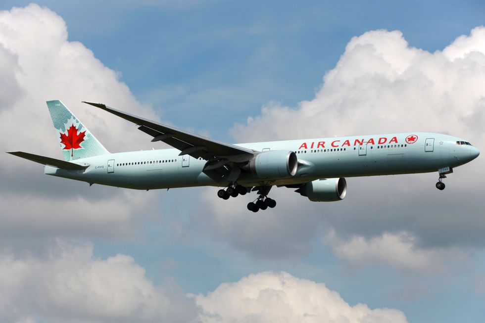 An Air Canada plane flying in the sky.