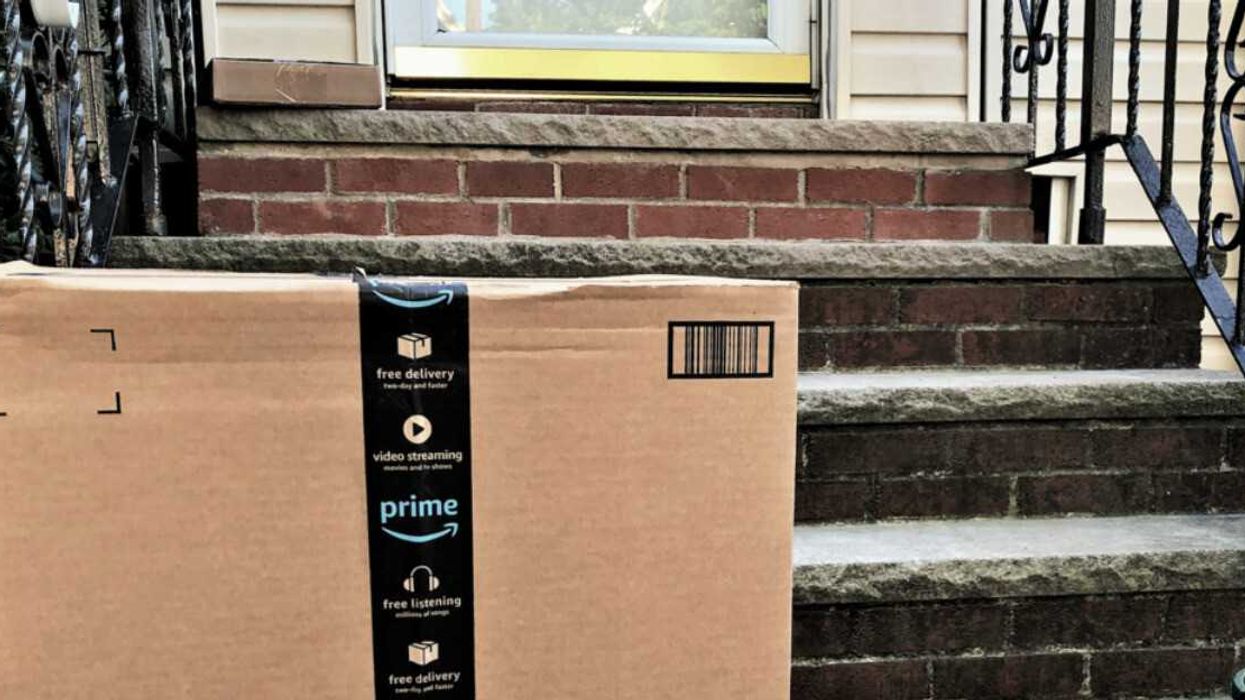 An Amazon Prime package sitting on front doorsteps.