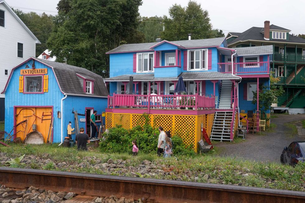 An antique store in an old house brightly painted in blue, pink and yellow.