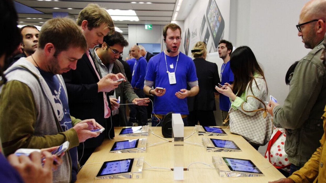 An Apple Store Genius with customers.