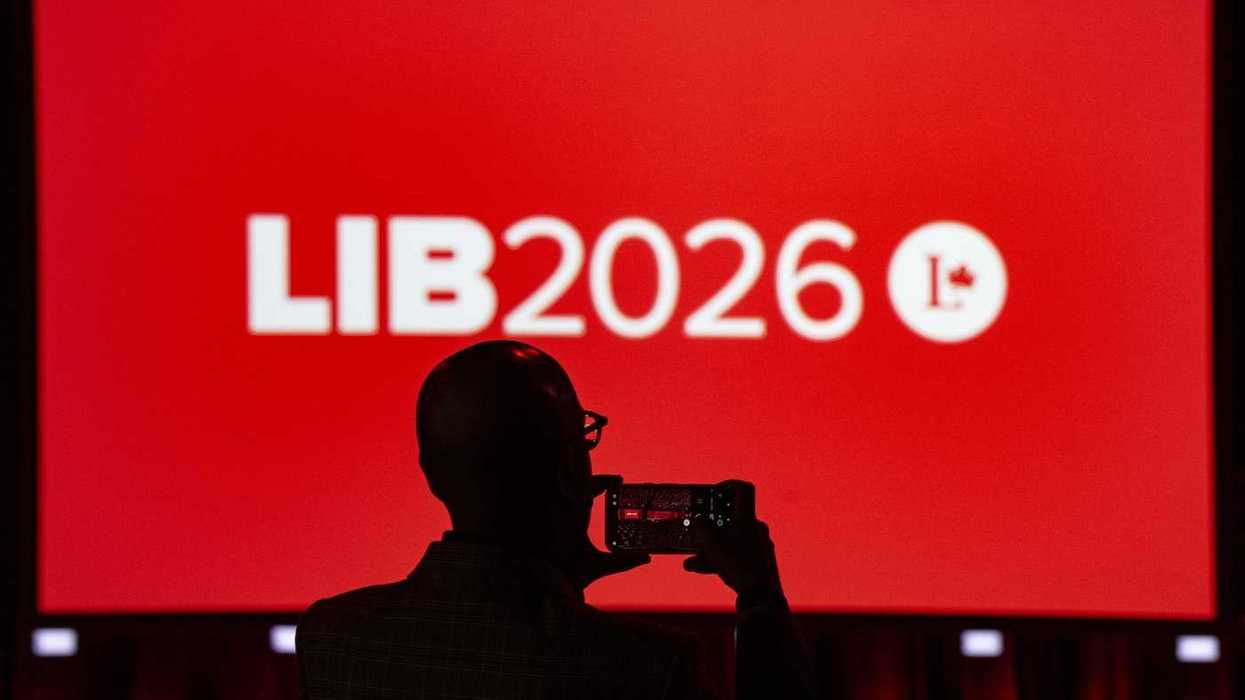 An attendee takes a photo of the main stage at the Liberal Convention