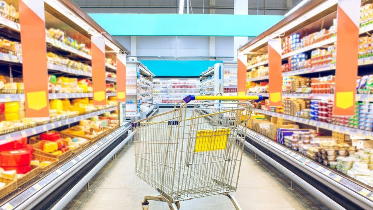 An empty grocery cart in a shopping aisle.