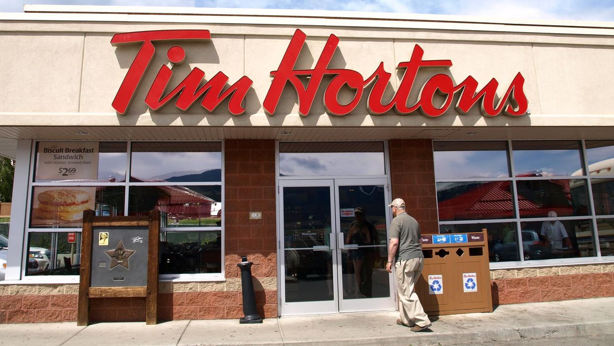 An entrance to a Tim Hortons restaurant on a sunny day.