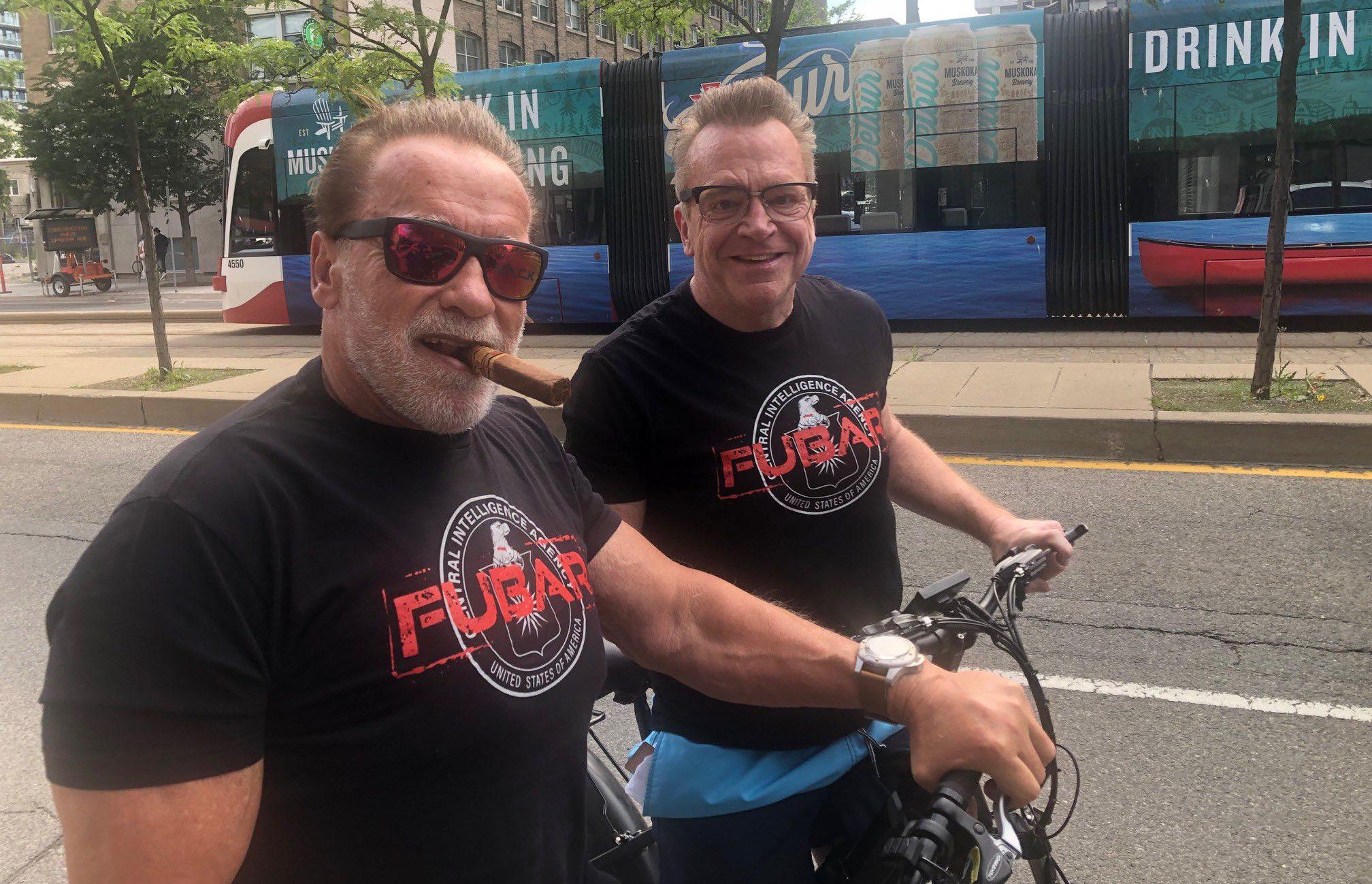 Arnold Schwarzenegger and Tom Arnold riding their bikes in Toronto.