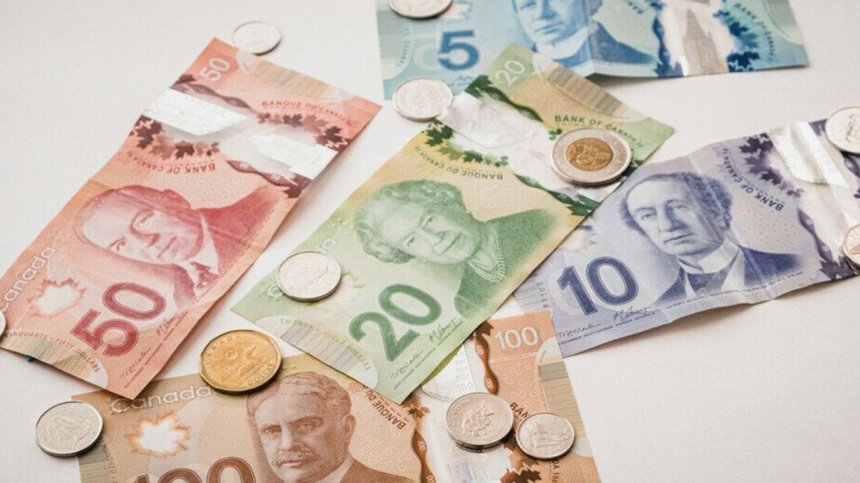 Assorted Canadian bills and coins on a white table.