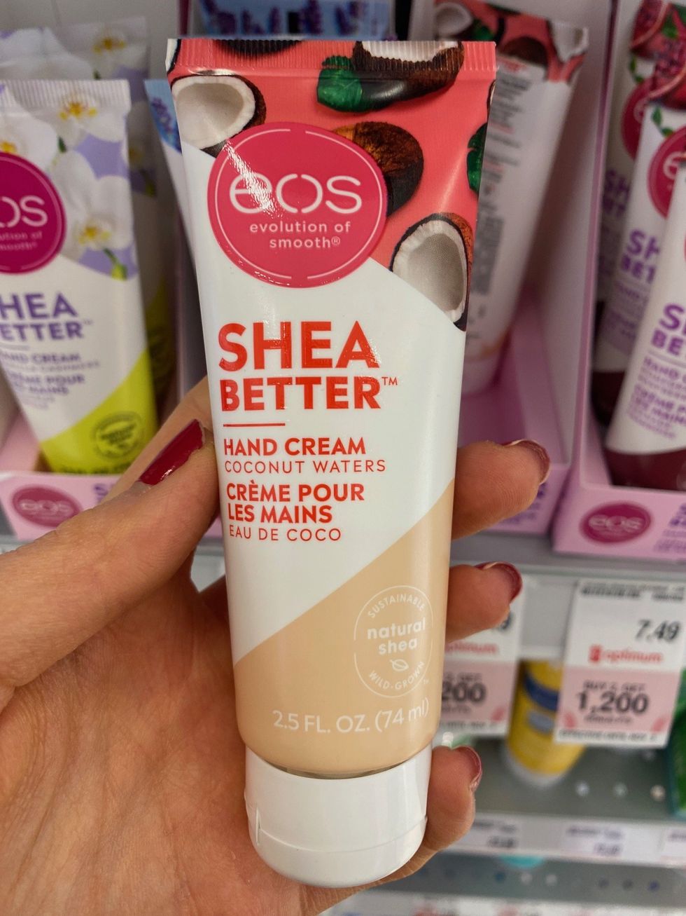 Asymina holding a bottle of eos shea better hand cream in a white and beige bottle.