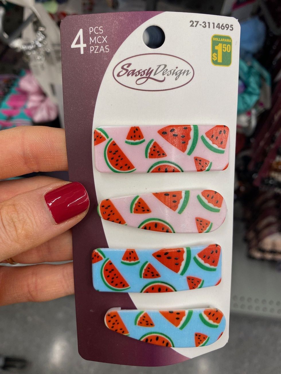 Asymina holding a four-pack of hair clips with watermelons on them at Dollarama.