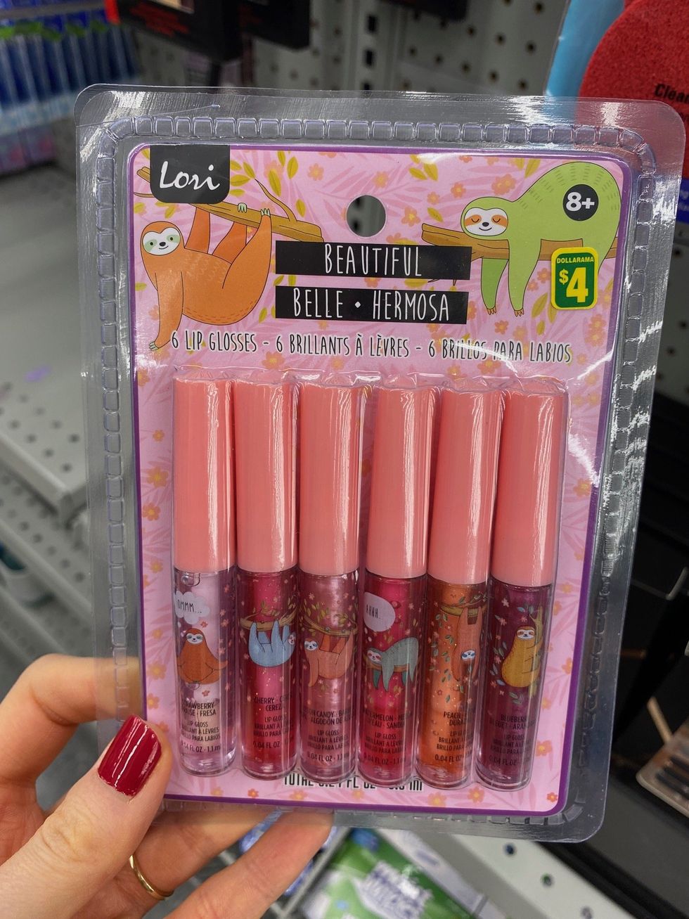 Asymina holding a six-pack of colourful lipglosses at Dollarama.