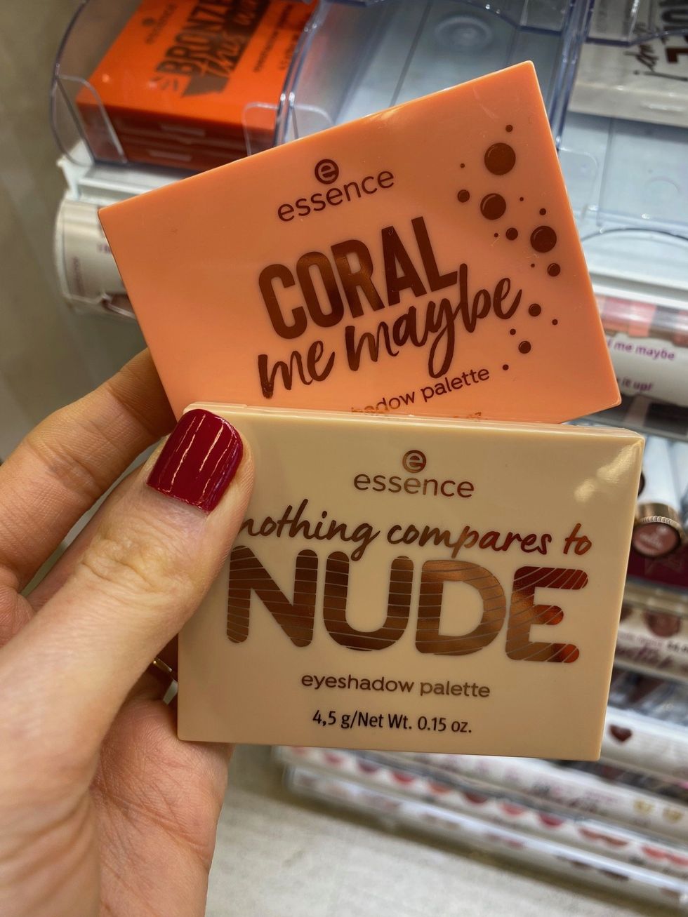 Asymina holding two palettes of eyeshadow in pink and beige packaging.