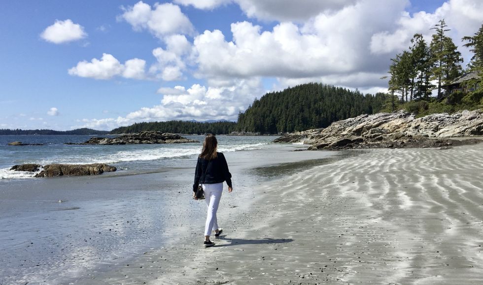 Asymina walking along a beach in Tofino, BC.