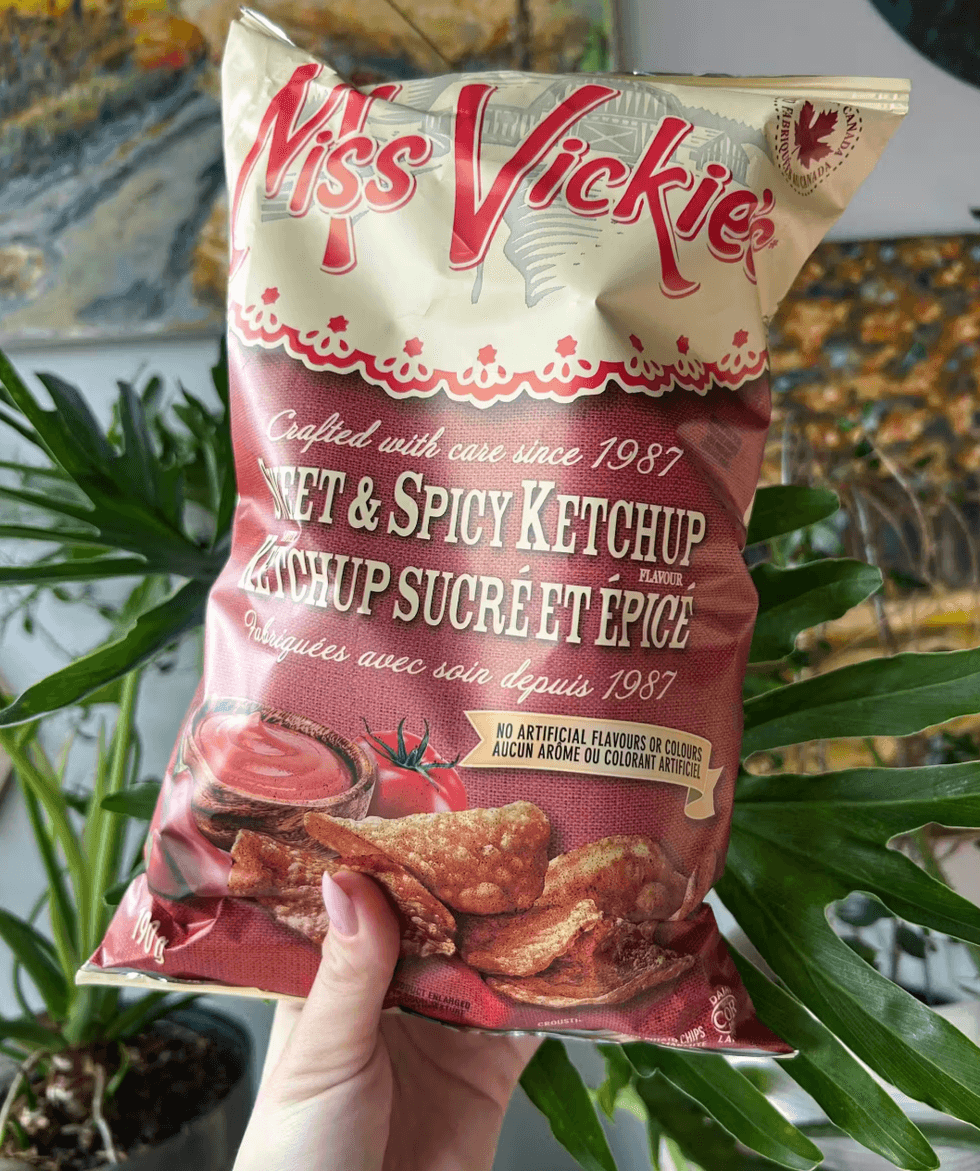 Author holding up a bag of spicy ketchup flavoured potato chips