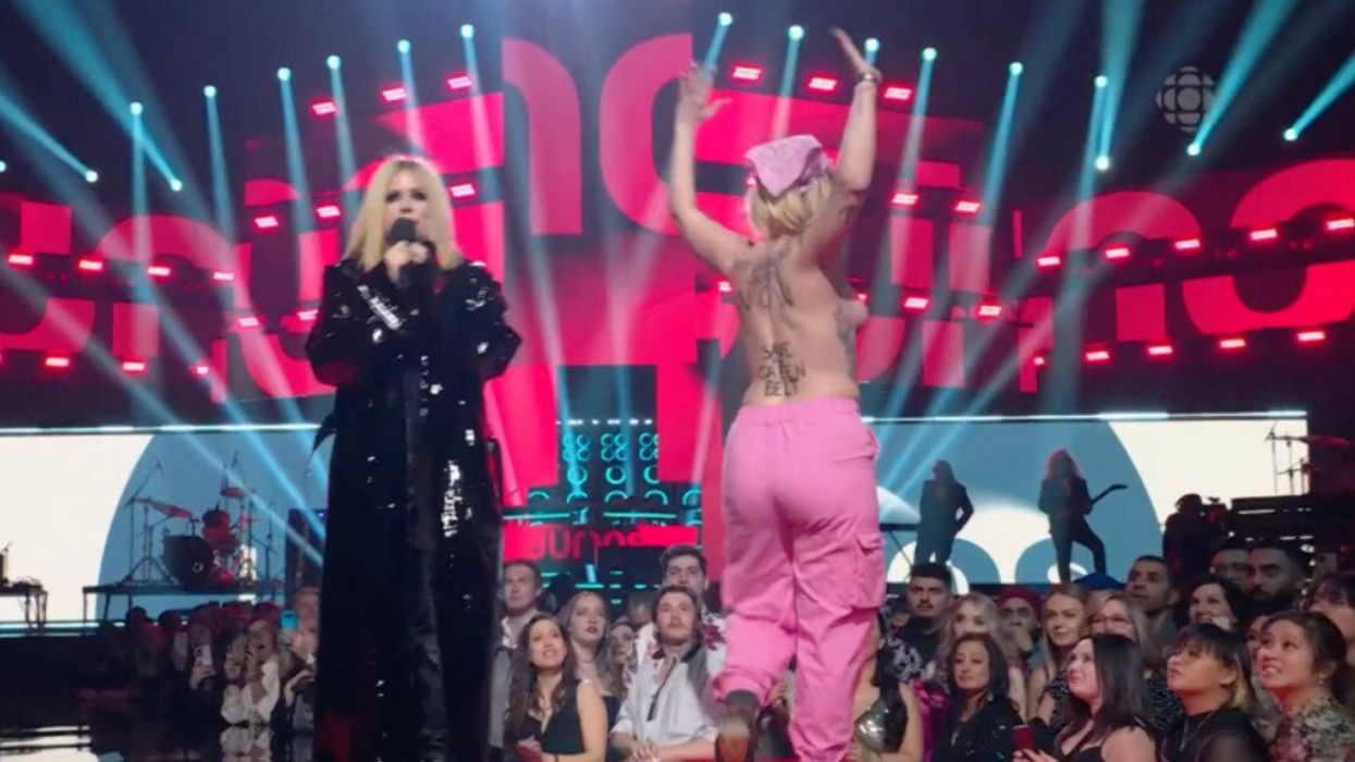Avril Lavigne and the protestor on stage at the JUNOS.