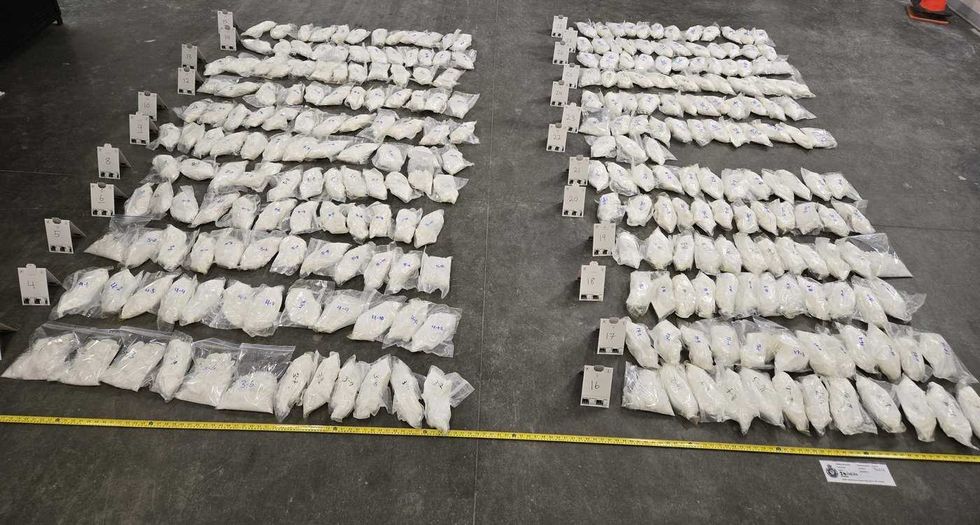 Bags of white crystals laid out on a concrete floor.