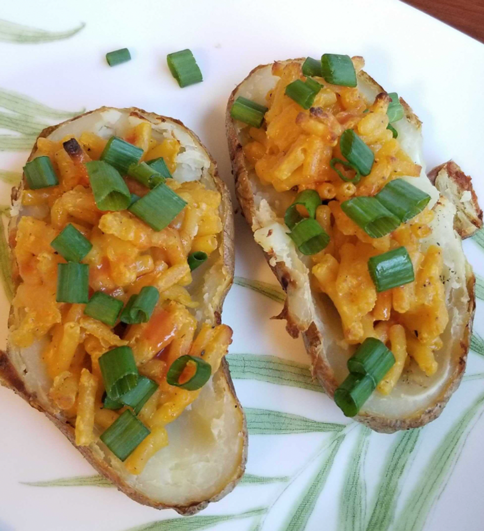 Baked potato with Kraft Dinner and green onion.