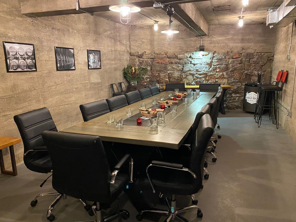 Bank vault dining room with long table & concrete walls in Ridge Rock Brewing Co Ottawa