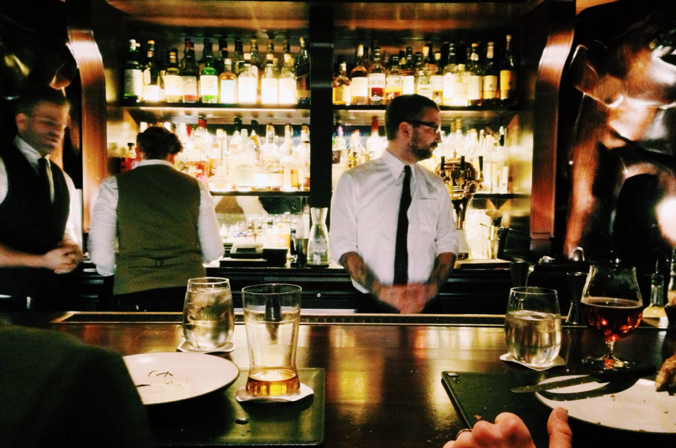 bartender standing beside table