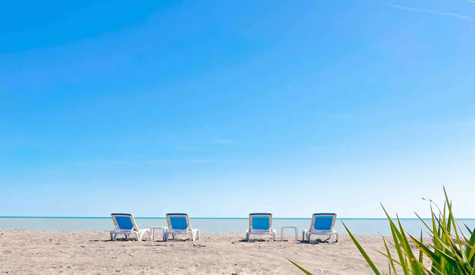 Beach chairs by the water.