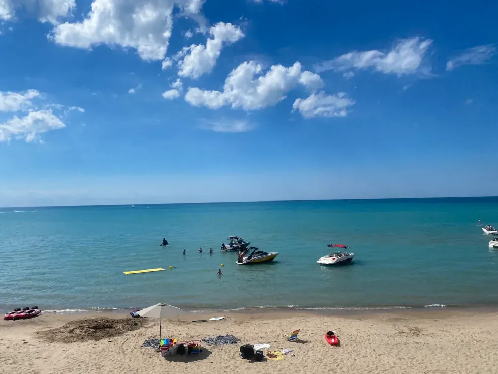 Beach with boats in the water.