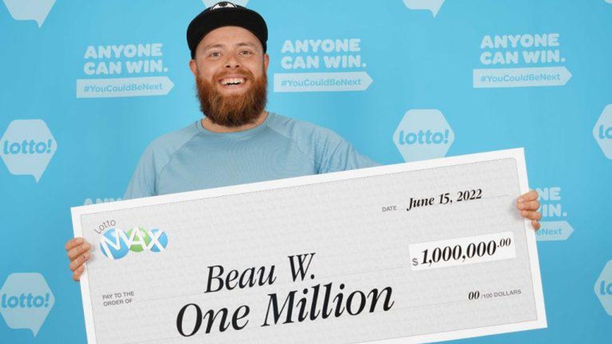 Beau Williams holding a giant Lotto Max cheque.
