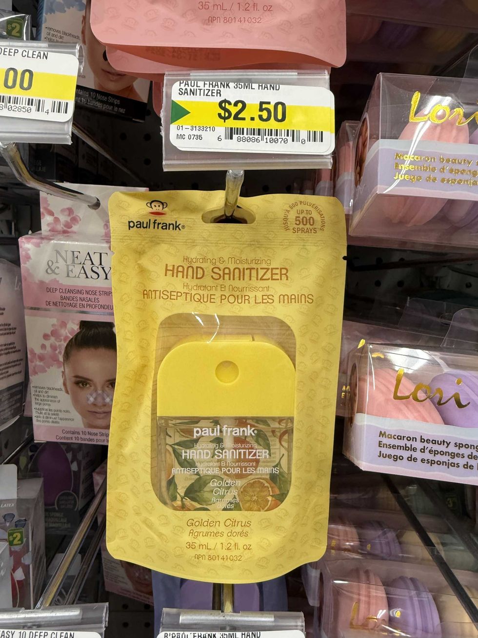 Beauty products on a store shelf, including a yellow bottle of Paul Frank hand sanitizer in the scent golden citrus.