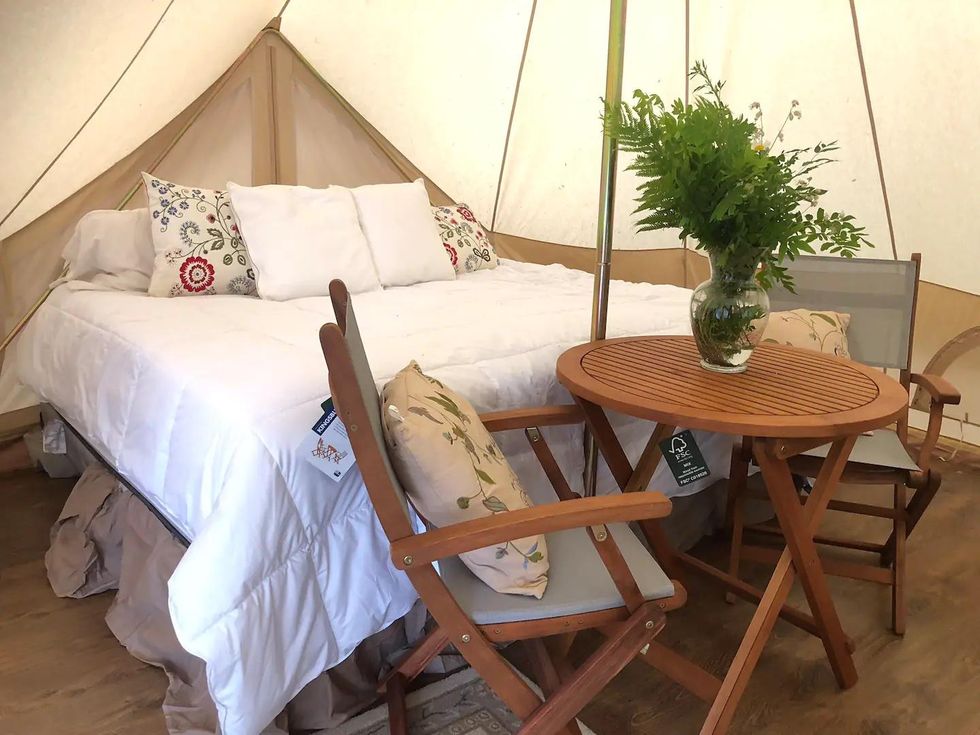 Bed and table set up in safari tent Airbnb on an Ontario island.