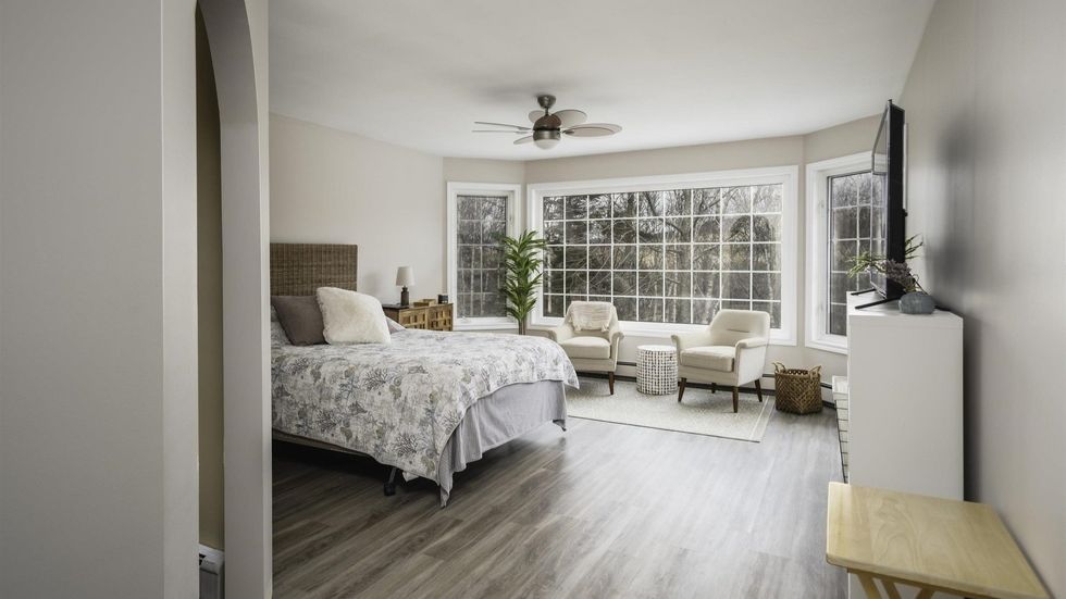 Bedroom in the home that has almost floor-to-ceiling windows.