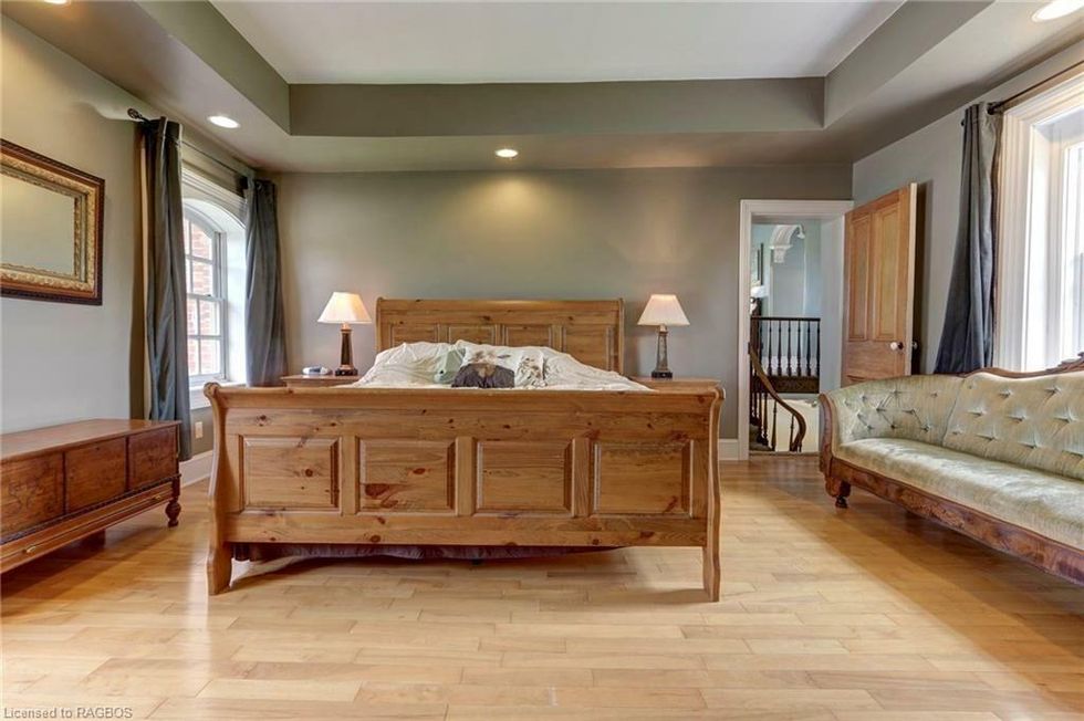 Bedroom with a wooden bed and couch.