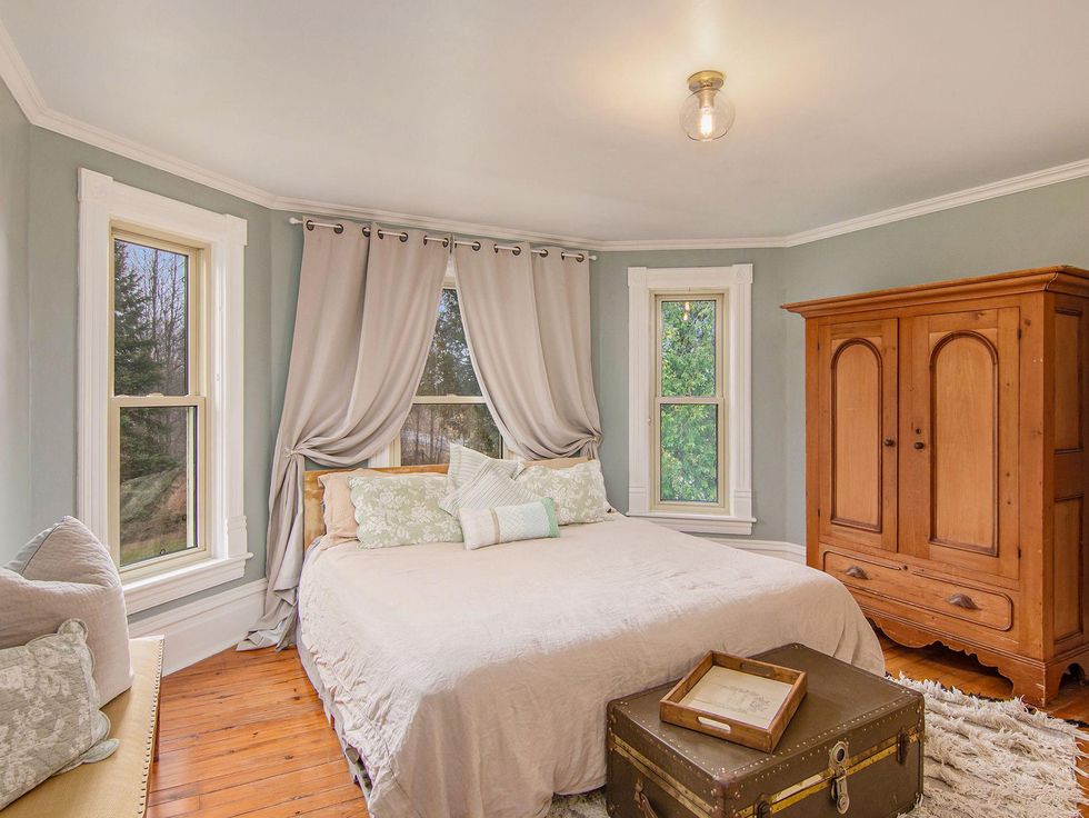 Bedroom with a wooden wardrobe and trunk.